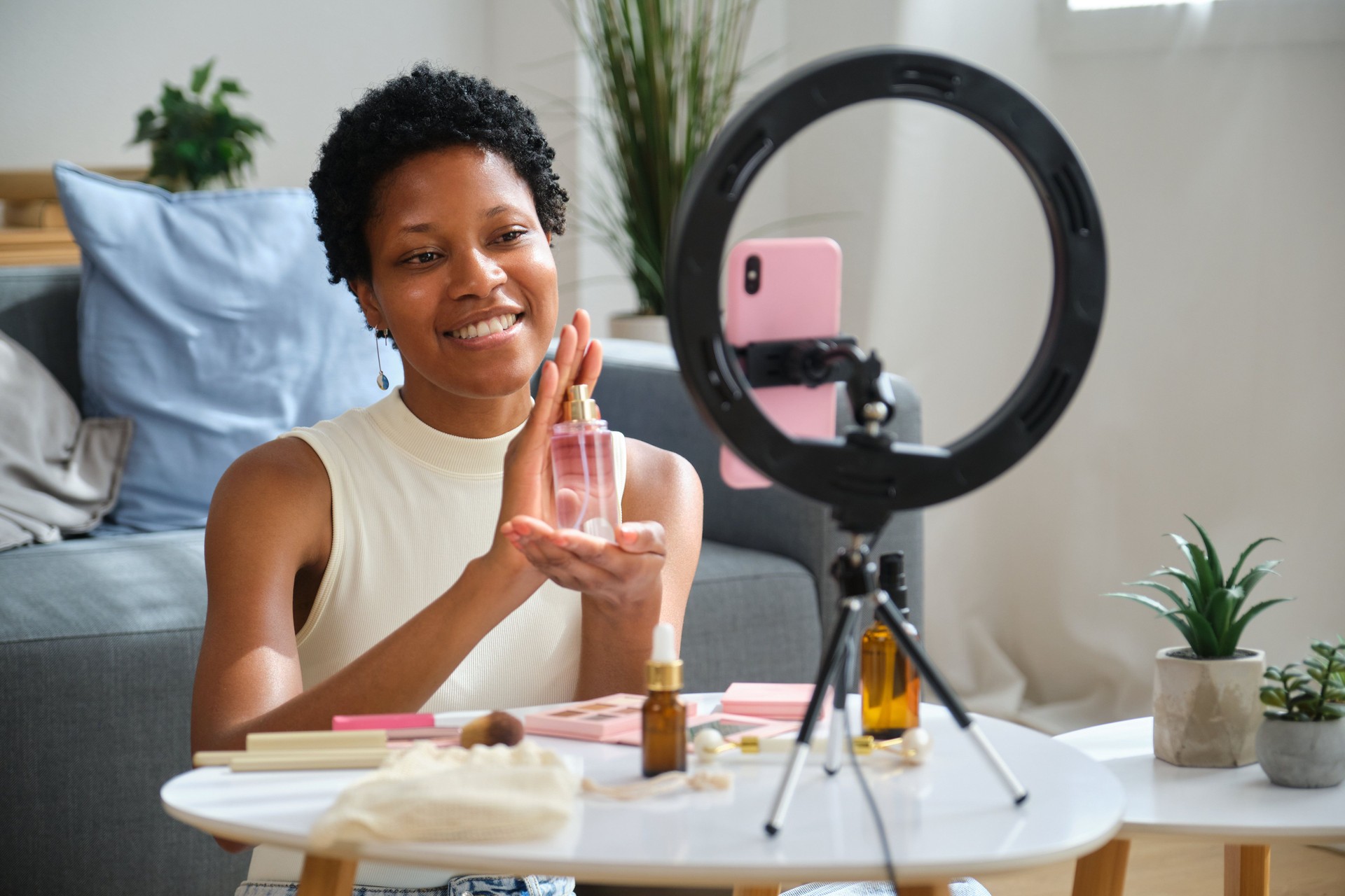 Beauty influencer is reviewing perfume using smartphone and ring light